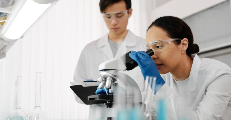 Researchers - Woman Looking at a Microscope