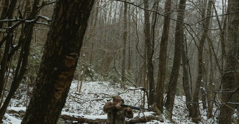 Poaching - Man Carrying a Riffle Hunting in the Forest